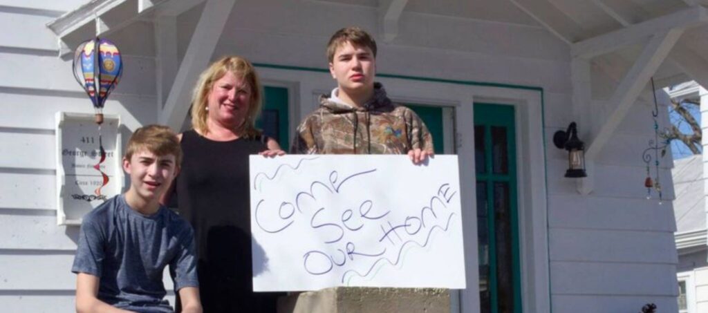Mother and two sons sitting on front porch
