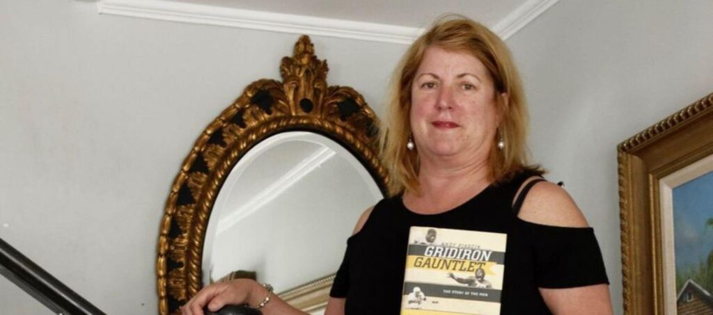 Christie Frazier standing on stairs holding book