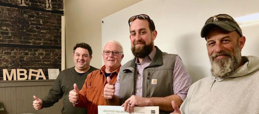 Four men giving thumbs up